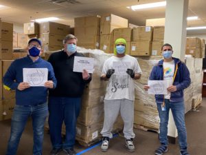 Four people holding signs thanking ProCure Hope for PPE donation
