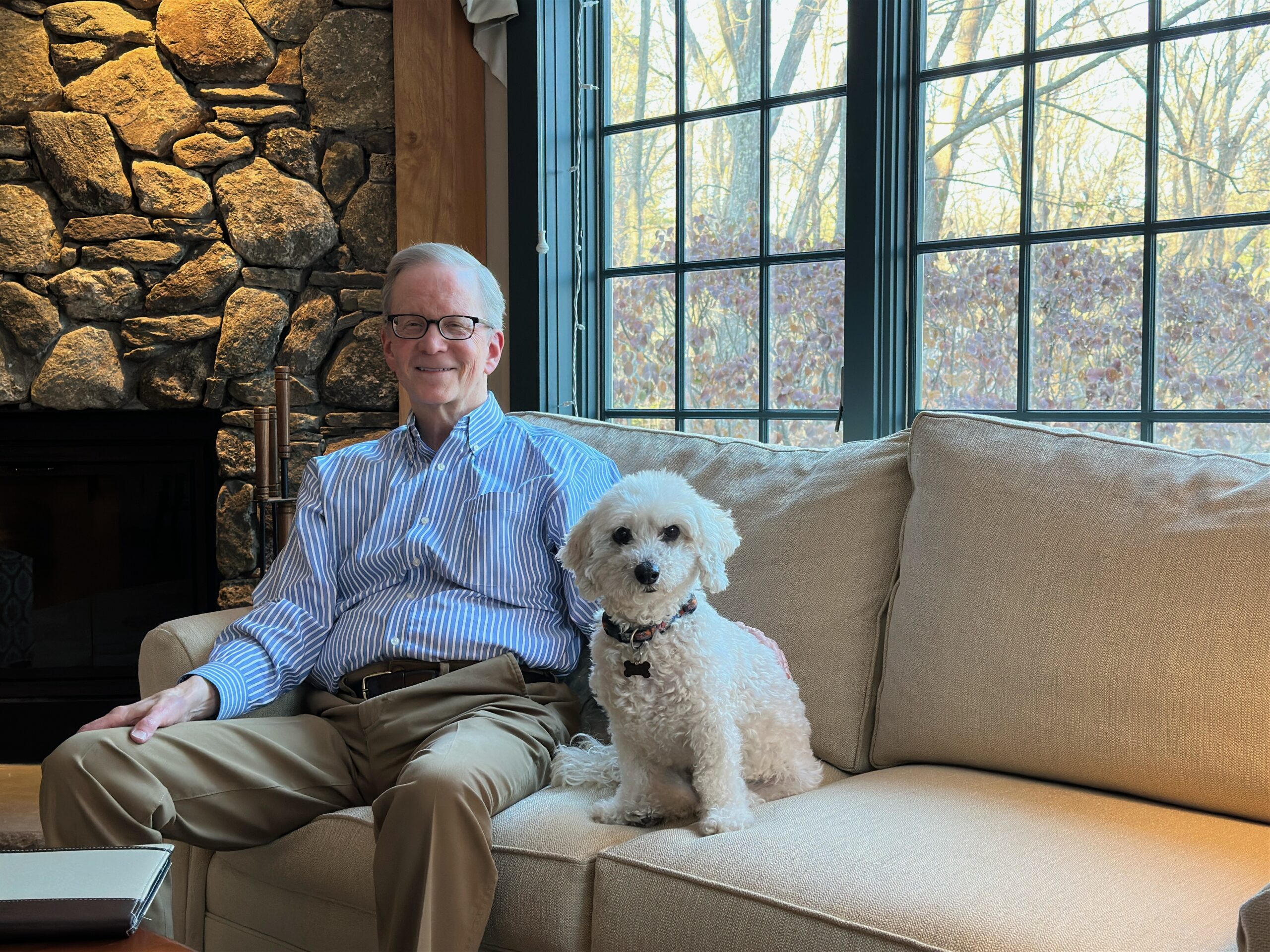 Jim McDaniel and his dog sitting on a couch.