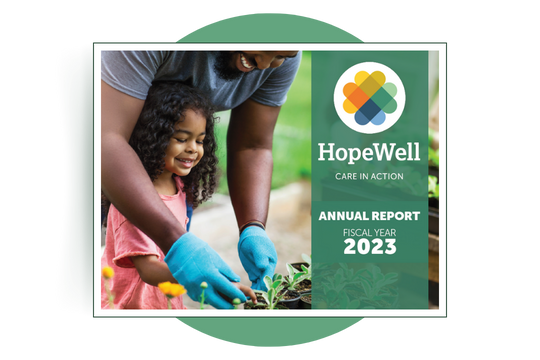 The front cover of HopeWell's FY23 Annual Report. There is a photograph of a man helping a young girl garden.