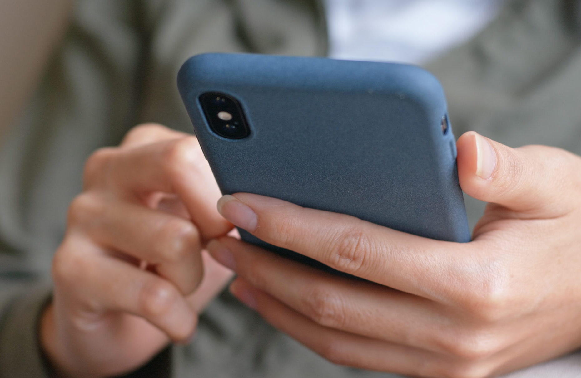 A close-up of a person's hands using a smart phone.