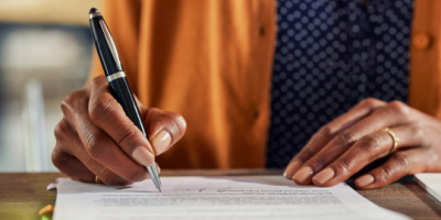 A close-up of a person completing an application.